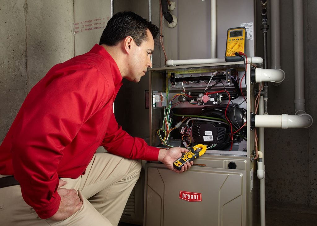 HVAC technician repairing an indoor furnace in Parker