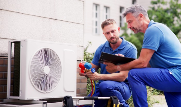 HVAC technicians installing an outdoor air conditioning unit in Parker