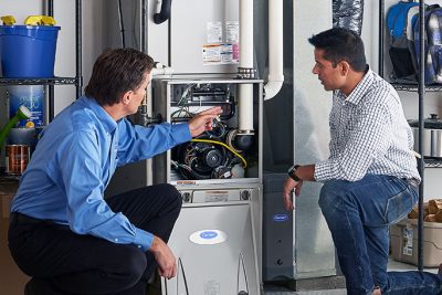 HVAC technician explaining furnace repair and maintenance to a homeowner in Parker, CO