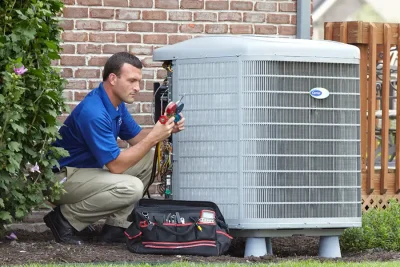 HVAC technician inspecting an outdoor air conditioning unit in Parker, CO