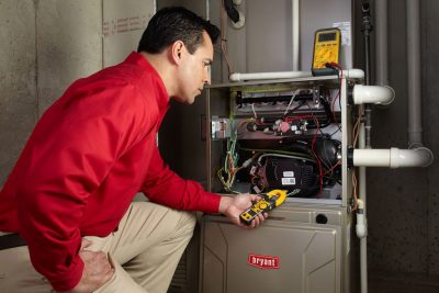 Heating and air conditioning technician servicing an indoor furnace in Parker, CO